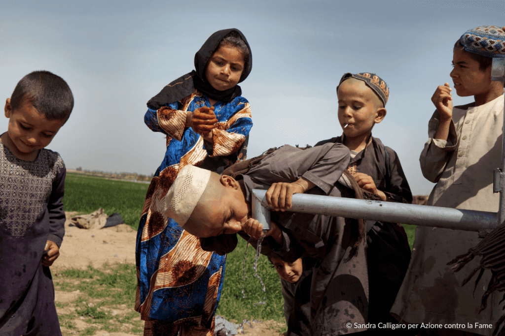 Bambini bevono da un rubinetto di acqua pulita appena intstallato fondamentale per combattere fame e malnutrizione
