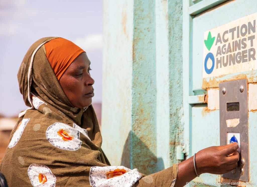 Donna in Kenya che utilizza distributore d'acqua